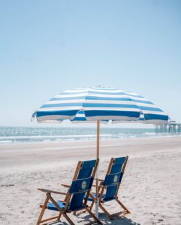 Umbrella dn chor and charis shown in a commercial beach rental setting