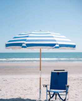 Agbrella sand anchor holding one umbrella next to a beach chair for commercial use