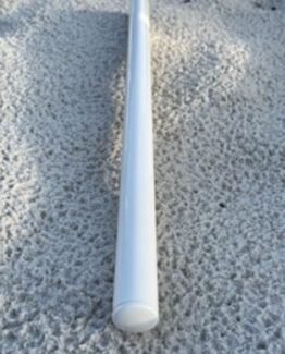 White PVC pipe with a capped end resting on rough concrete ground, viewed from above.