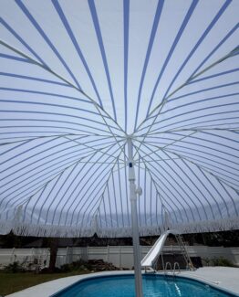umbrella with blue stripe with fringe near a pool