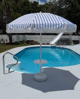 umbrella with stripes and tassel by a pool