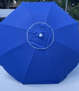 Blue outdoor umbrella canopy fully opened on a white surface, with a white inner ring and center hub visible.