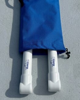 Pair of white snorkeling/diving fins sticking out from a blue bag on a gray surface, ready for use or transport.