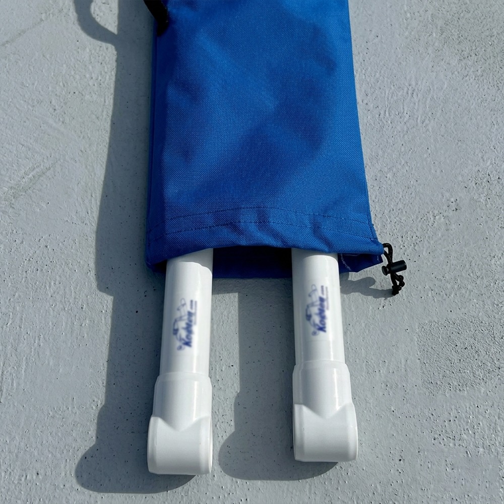 Pair of white snorkeling/diving fins sticking out from a blue bag on a gray surface, ready for use or transport.
