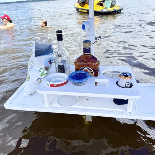 photo of a table being used at a sandbar holding an umbrella and cocktails.