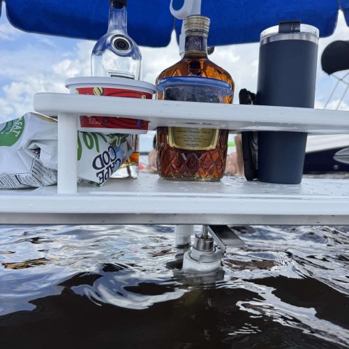 photo of a table the securely hold liquor bottles at a sandbar.